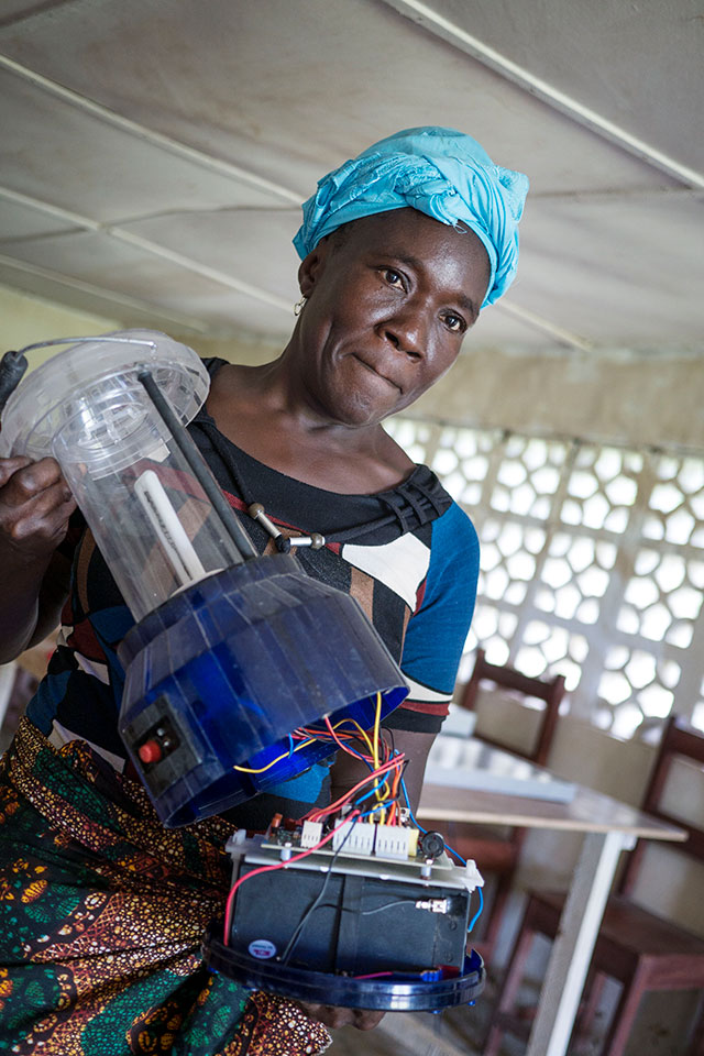 Bendu Sackie, a 55-year-old solar engineer displays the circuit board of a solar lantern that she assembled.