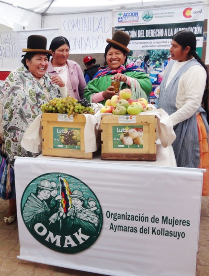 Lucrecia and classmates from the Organización de Mujeres Aymaras de Kollasuyo (OMAK) display products they grew in the community of Luribay without agrochemicals to support their economic empowerment. Photo: OMAK.